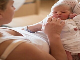 Mujer con bebé usando una faja postparto adecuada.