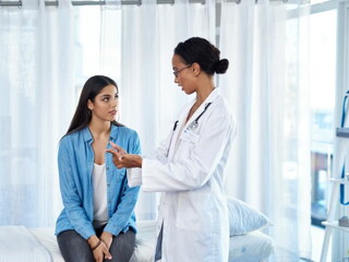 Mujer teniendo una consulta médica con la especialista en Fertilidad